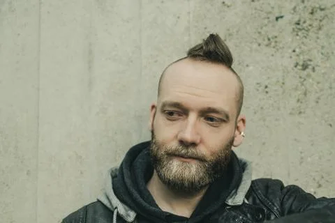 Thinking bearded man looking down in front of a wall Stock Photos