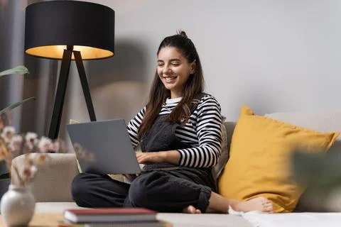 Thinking of bright future attractive student female working on laptop at home Stock Photos
