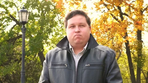 Thinking businessman looking at camera in autumn park Stock Footage 80920618