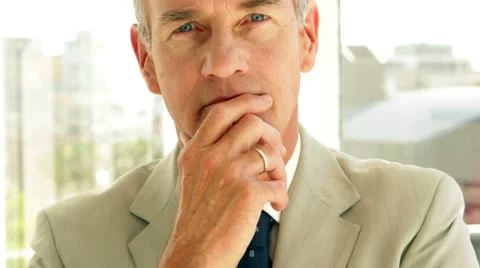 Thinking businessman looking at camera Stock Footage