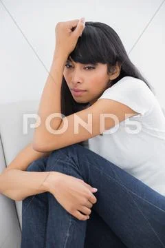 Thinking calm woman sitting on couch Stock Photos