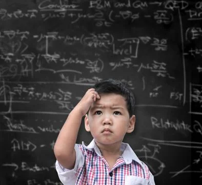 Thinking child with a blackboard in the background Stock Photos