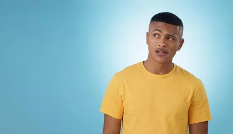 Thinking, confused or problem solving and a man on a blue background in studio Stock Photos