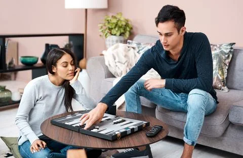 Thinking, couple and playing backgammon at house with strategy, moving piec.. Stock Photos