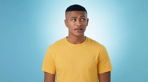 Thinking, doubt or problem solving and a man on a blue background in studio with Stock Photos