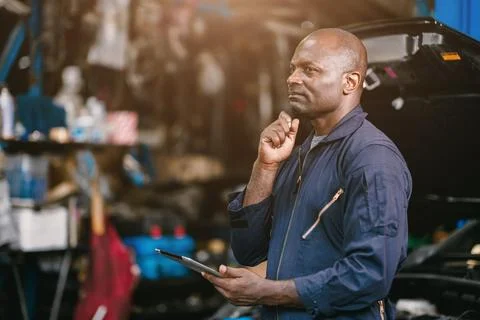 Thinking Garage Worker. Intelligence Mechanic auto service. African male th.. 스톡 사진
