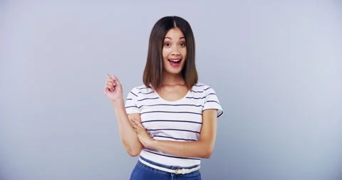 Thinking, hand pointing and face of happy woman in studio with plan, solution or 動画素材 255008243