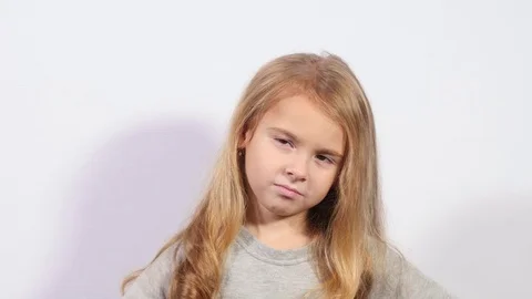 Thinking kid looking up and around. Beautiful young girl on white background Stock Footage 70284234