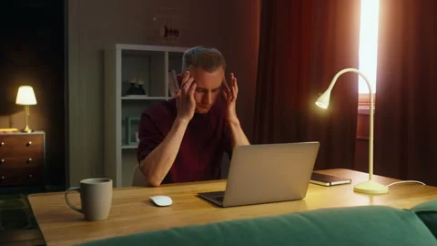 Thinking man work at home with laptop suffer headache. Guy feel bad, head pain. Stock Footage 322755126
