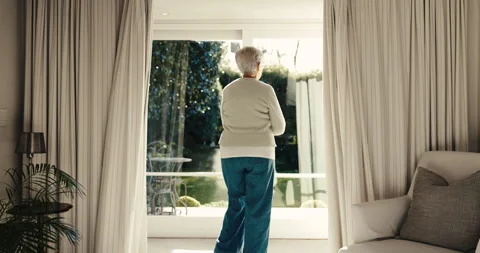 Thinking, open and old woman at window with curtains, daydreaming and chill Stock Footage 342253104