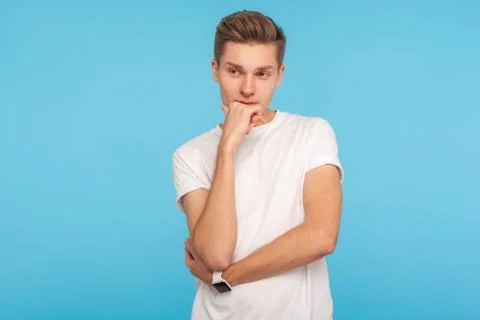 Thinking over idea. Portrait of smart pensive man in casual white t-shirt con Foto stock