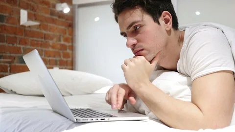 Thinking Pensive Man in Bed Working on Laptop at Night Stock Footage 83805843