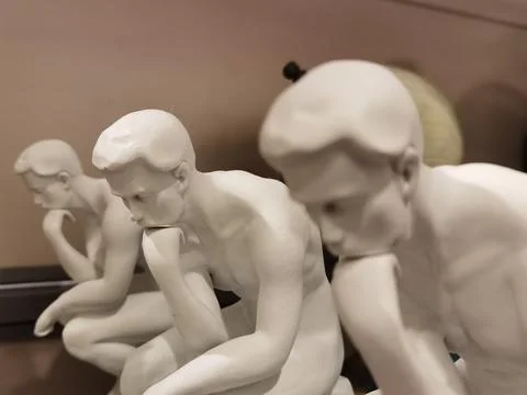 Thinking person but three figures in a row, unpainted in white Stock Photos