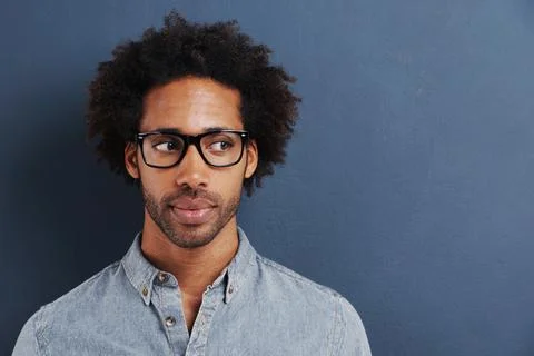 Thinking in progress...a handsome young man wearing glasses glancing sideways. Stock Photos