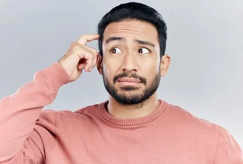 Thinking, question and doubt with a man in studio on a gray background looking Stock Photos