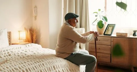 Thinking, sad or old man in bedroom with walking stick, loss or memory of p.. Stock Photos