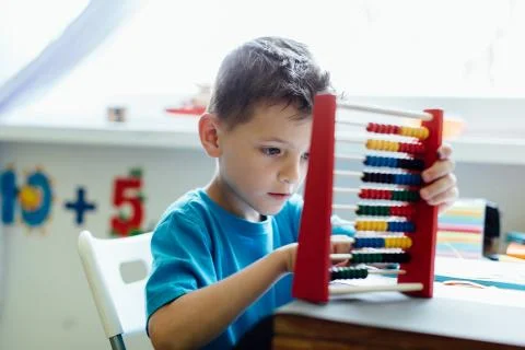 Thinking schoolboy learning maths with an abacus Stock Photos