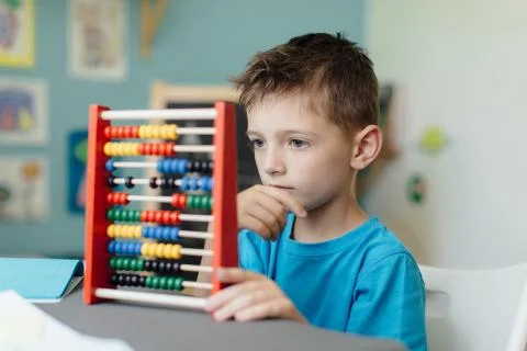 Thinking schoolboy learning maths with an abacus Stock Photos