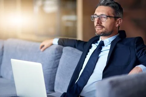 Thinking, sofa and business man on laptop for planning, working online and Stock Photos