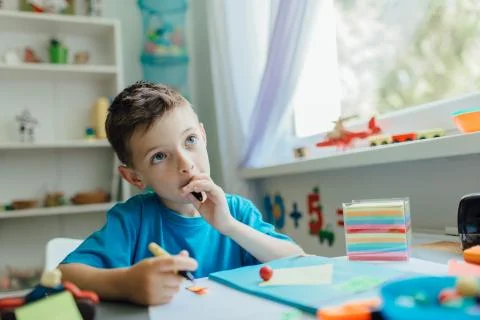 Thinking student doing his homework at home Stock Photos