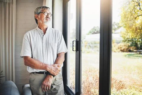 Thinking, window and senior man at his home with memory, reflection or remember Stockfoto's