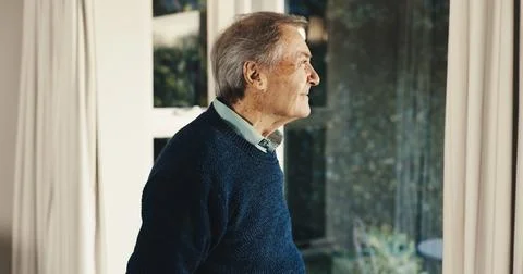 Thinking, window and senior man in home with reflection, memory or retirement Stock Photos