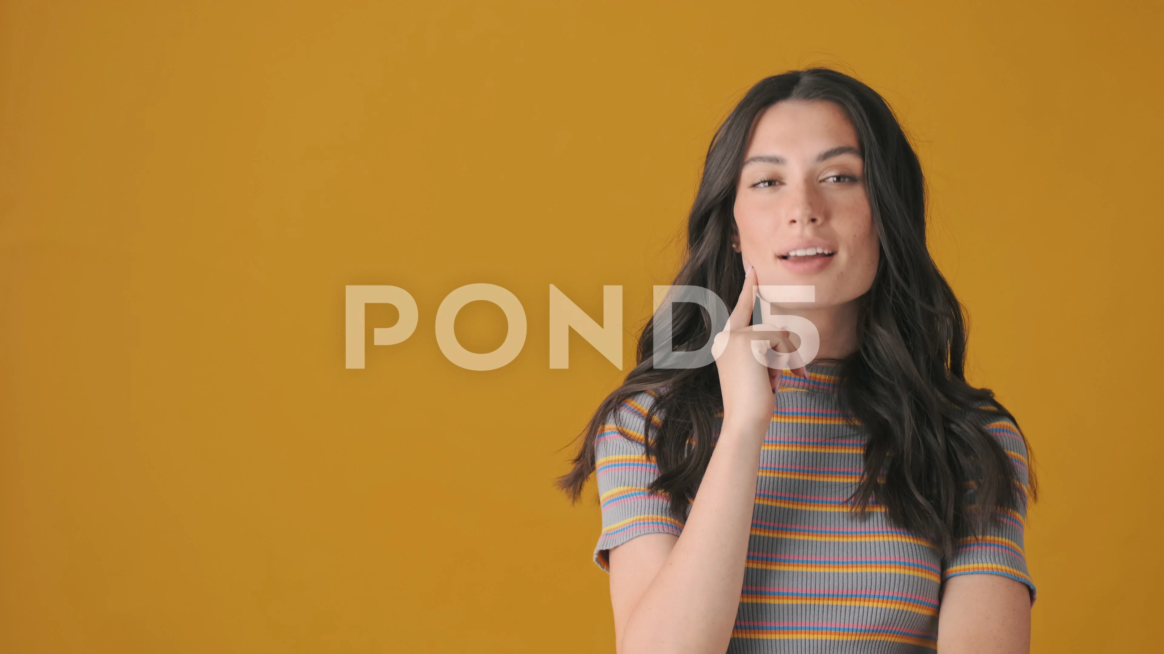 A thinking woman nodding and standing near free space in the yellow studio