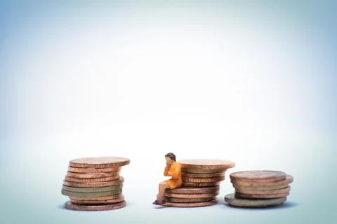 Thinking woman sitting on coin stack. Stock Photos