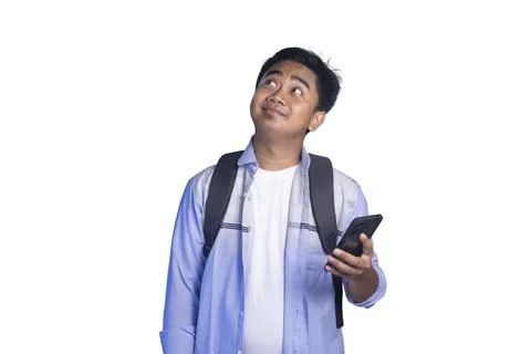 Thinking young male student with a backpack holding a smartphone to his chi.. Stock Photos