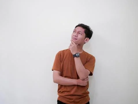 Thinking Young Man Looking Up Against White Wall Stock Photos