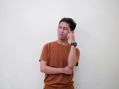 Thinking Young Man Looking Up Against White Wall Stock Photos