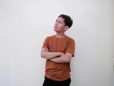 Thinking Young Man Looking Up Against White Wall Stock Photos