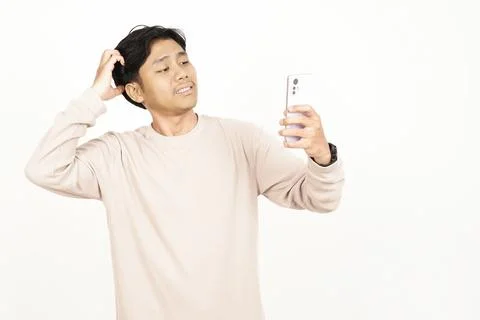 Thinking young man looking at smartphone screen with doubt Stock Photos