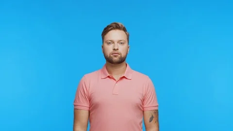 Thinking young man over vibrant background. Studio portrait of expressive Stock Footage 123545633