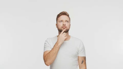 Thinking young man over vibrant background. Studio portrait of expressive Stock Footage 123545713