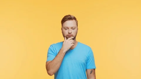 Thinking young man over vibrant background. Studio portrait of expressive Stock Footage 123546071