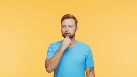 Thinking young man over vibrant background. Studio portrait of expressive Stock Footage 125066230