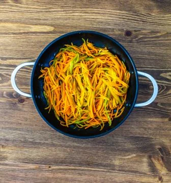 Thinly cut thin strips of carrots. fried and stewed carrot spaghetti in a pan on Foto stock