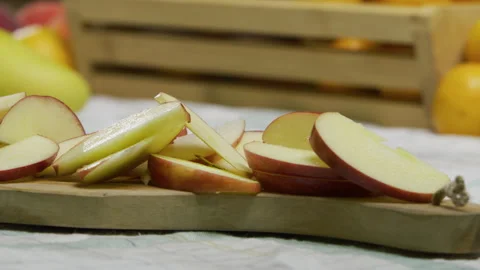 Thinly sliced apples on wooden cutting board - closeup, panning shot Stock Footage 341244337