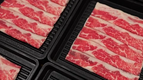 Thinly Sliced Beef for Shabu Shabu with Dark Sukiyaki Broth Stock-Footage 345223111