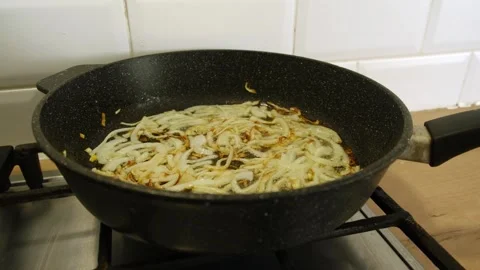 Thinly sliced onions are fried in hot oil Stock Footage 334318053