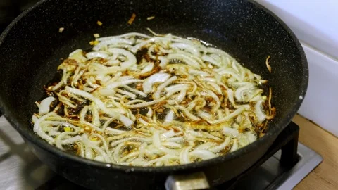 Thinly sliced onions are fried in hot oil Stock Footage 336066910