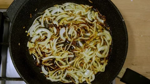 Thinly sliced onions are fried in hot oil Stock Footage 337289885