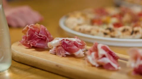 Thinly Sliced Prosciutto Ham Served on a Wooden Charcuterie Board Stock Footage 337394875