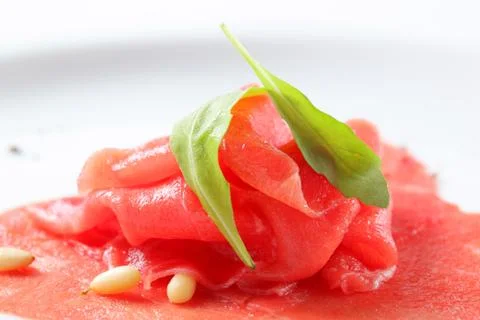 Thinly sliced raw beef with pine nuts Stock Photos