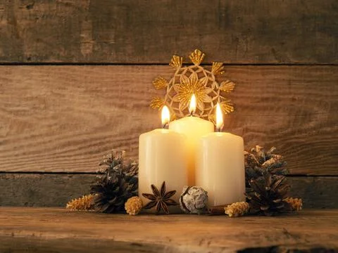 Third Advent candle burning on a rustic wooden table Stock Photos