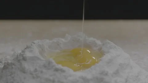 A third egg is cracked into flour bowl Stock Footage 149107666