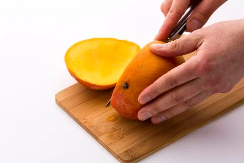 Third of a mango sliced off in a first cut Stock Photos