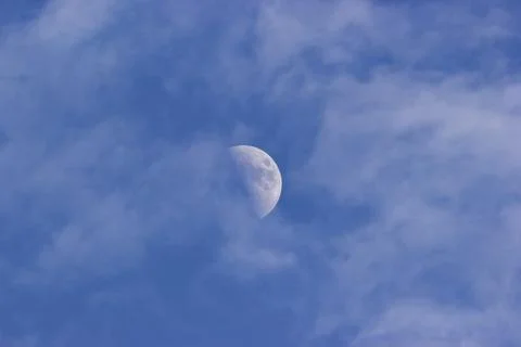 Third Quarter Moon through clouds Stock Photos