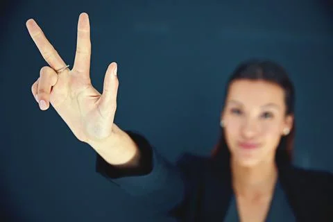 Third time lucky. Portrait of a young businesswoman showing a number with her Stock Photos